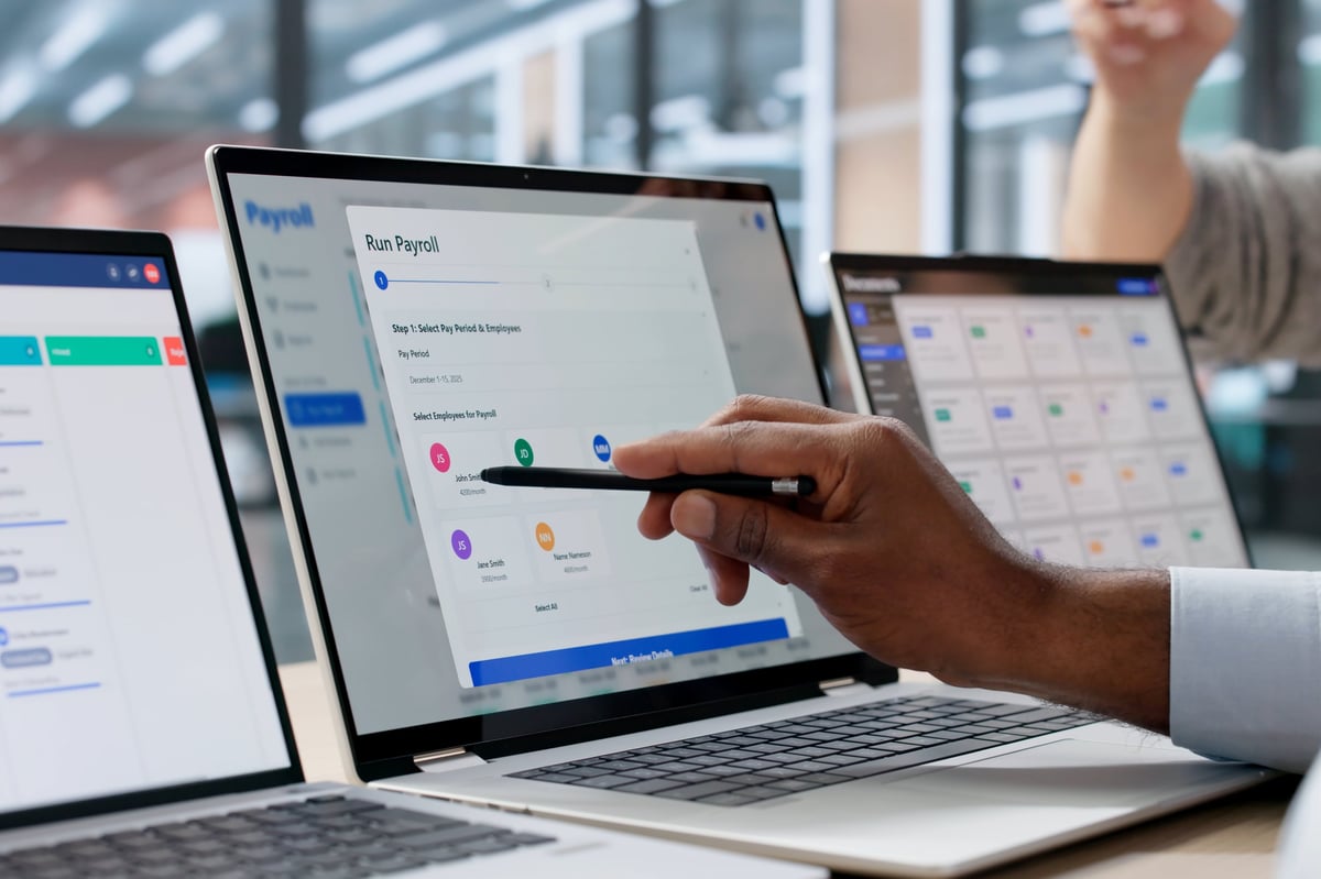 Young African American Man And Woman Use Laptop To Calculate Payroll And Manage Finances